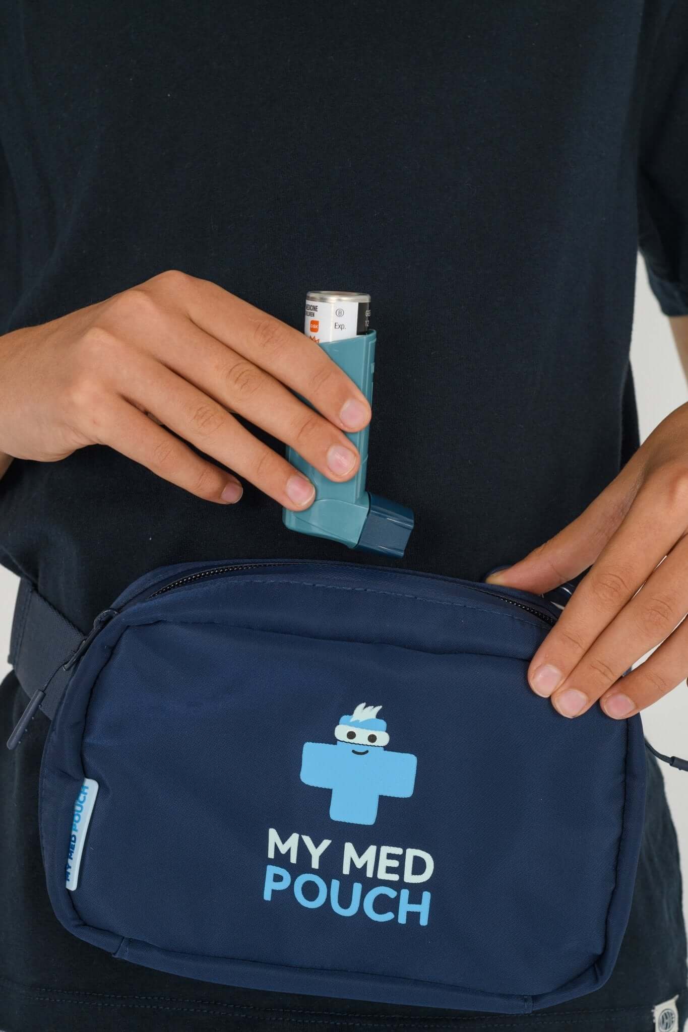 Navy Med Ready Bag being worn as a waist bag with child placing an asthma inhaler in the bag. 